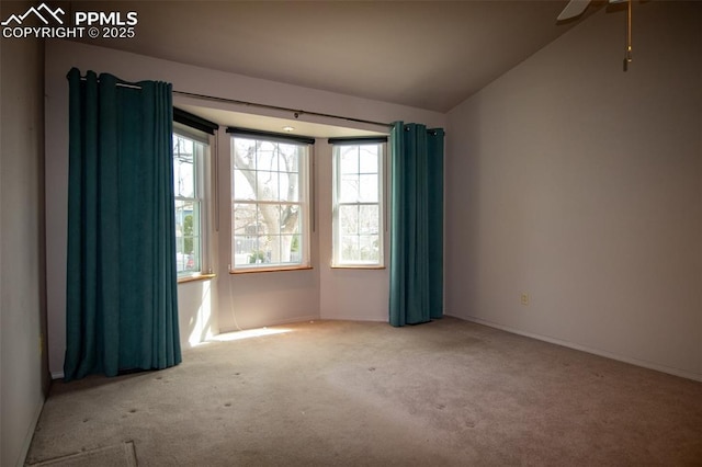 carpeted spare room with vaulted ceiling and a ceiling fan