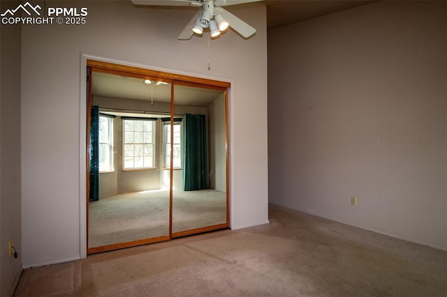 unfurnished bedroom featuring carpet floors, ceiling fan, and a closet