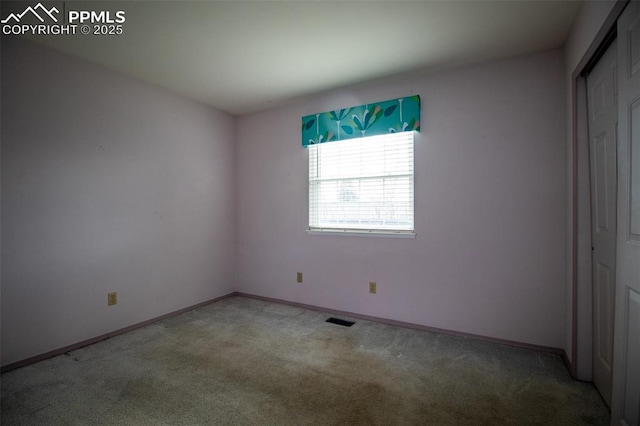 unfurnished bedroom featuring carpet floors, baseboards, visible vents, and a closet