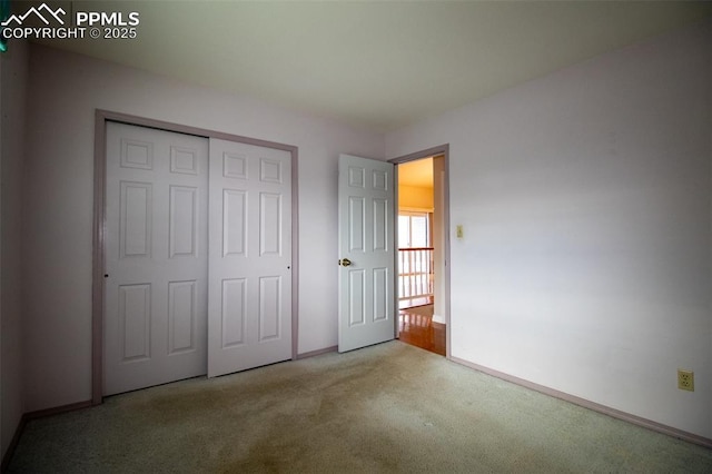 unfurnished bedroom featuring carpet, baseboards, and a closet