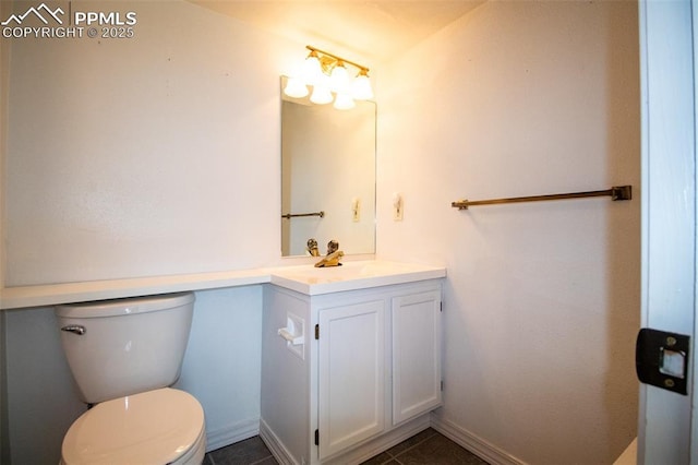 half bathroom with toilet, tile patterned floors, baseboards, and vanity