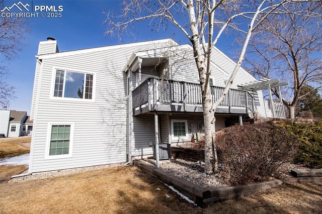 back of property featuring a deck, a chimney, cooling unit, and a pergola