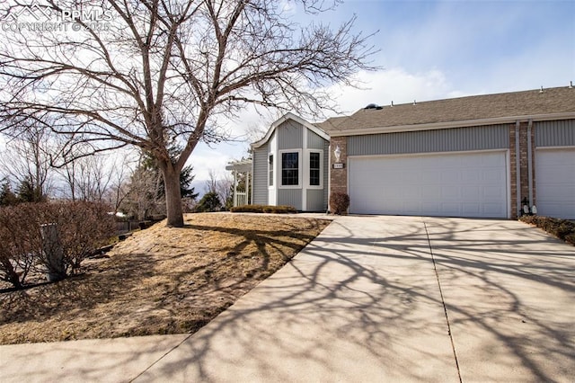 view of front of house featuring concrete driveway, brick siding, and an attached garage