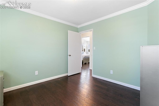 empty room with dark wood-type flooring, crown molding, and baseboards