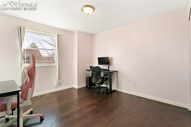 office space featuring baseboards, a textured ceiling, visible vents, and wood finished floors