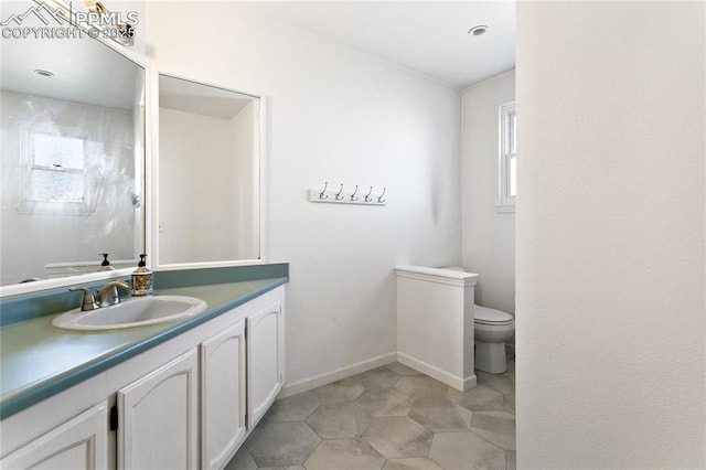 bathroom with vanity, toilet, and baseboards