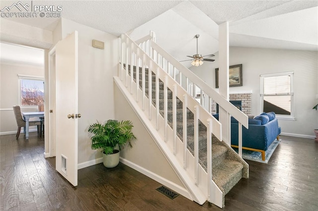 staircase with lofted ceiling, wood-type flooring, baseboards, and ceiling fan