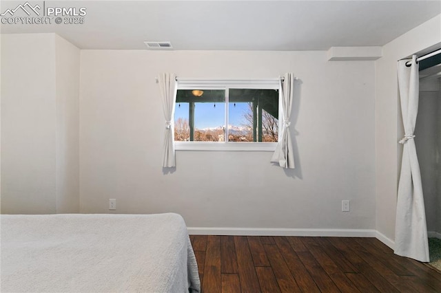 bedroom with visible vents, baseboards, and hardwood / wood-style flooring