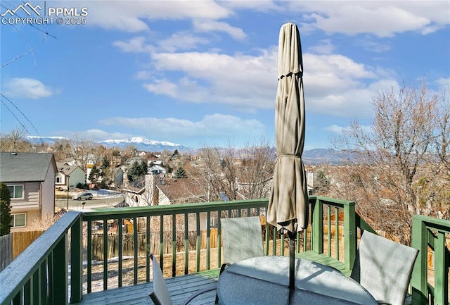 wooden terrace featuring a residential view, outdoor dining area, and a mountain view