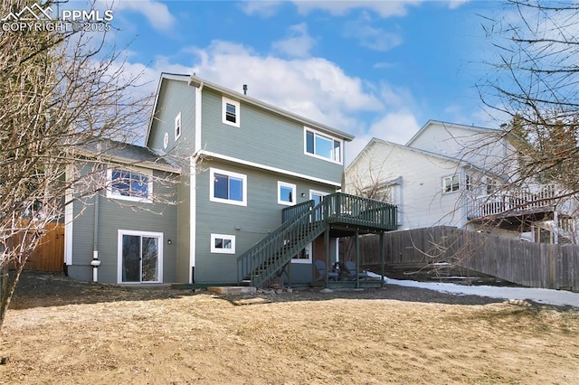 back of property with stairs, fence, and a deck