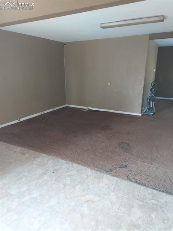 unfurnished room with baseboards and carpet floors