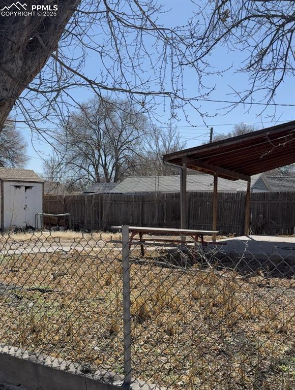 view of yard featuring a shed, an outdoor structure, and a fenced backyard