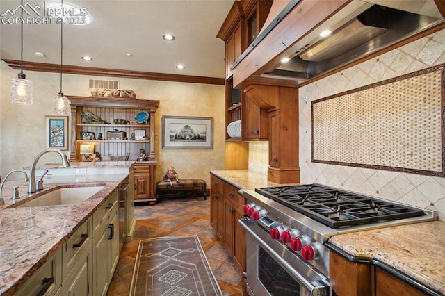 kitchen with a sink, brown cabinetry, decorative backsplash, wall chimney exhaust hood, and stainless steel range