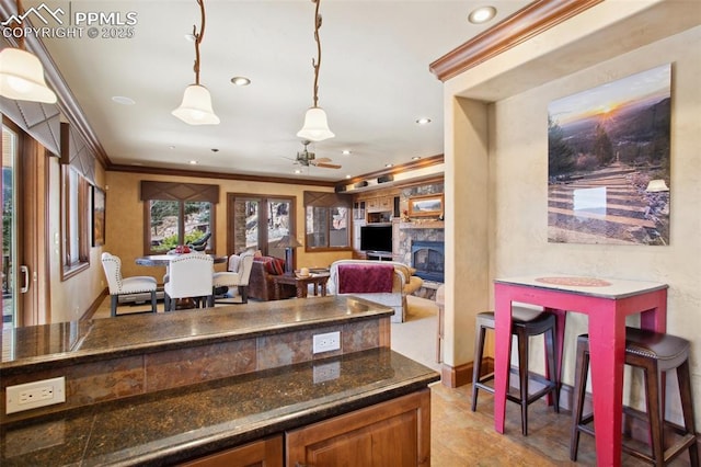 kitchen with decorative light fixtures, a fireplace, crown molding, recessed lighting, and ceiling fan