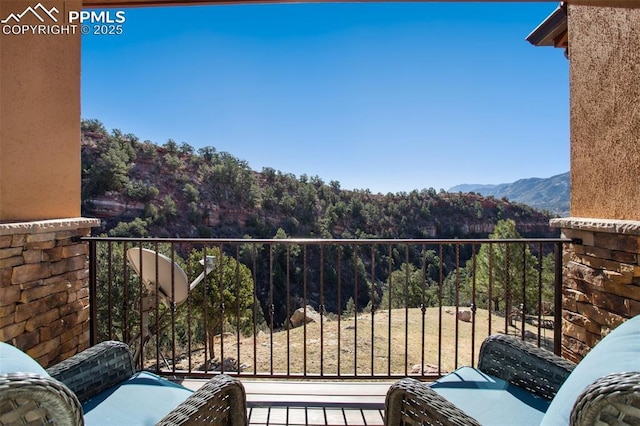 balcony with a mountain view and a view of trees