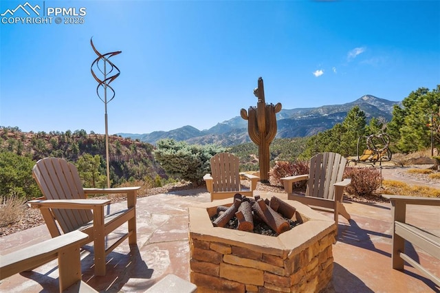 view of patio / terrace featuring a fire pit and a mountain view