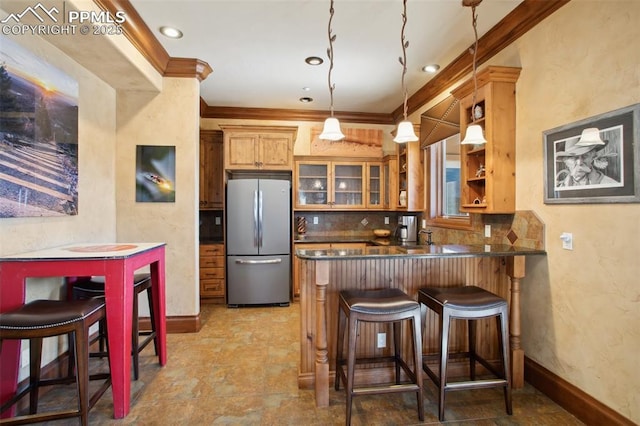 kitchen featuring tasteful backsplash, dark countertops, ornamental molding, freestanding refrigerator, and open shelves