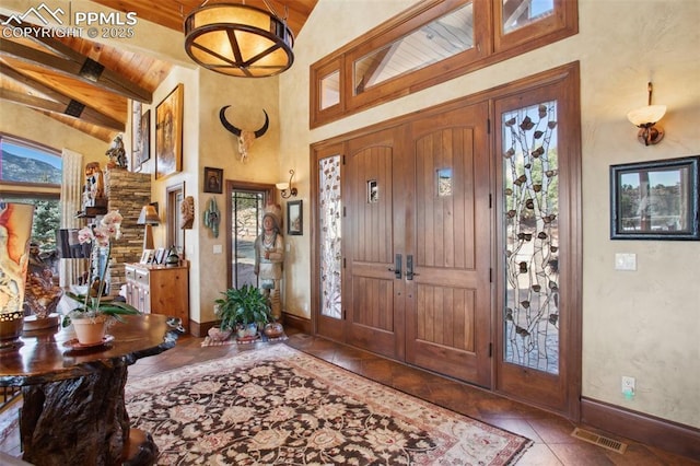 entrance foyer featuring high vaulted ceiling, visible vents, baseboards, tile patterned floors, and beamed ceiling