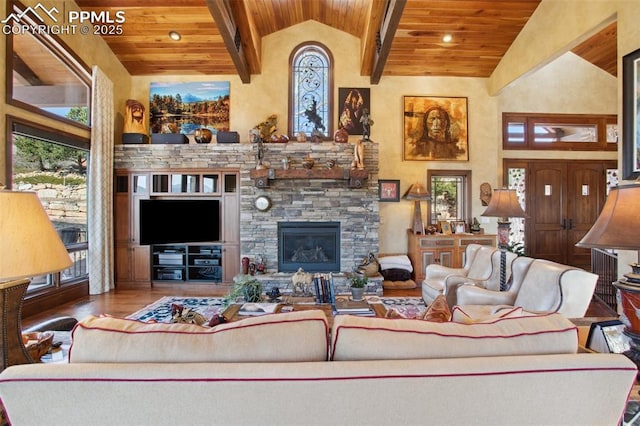 living room with high vaulted ceiling, a stone fireplace, wooden ceiling, and beam ceiling