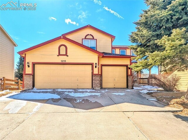 view of front of home with a garage, fence, brick siding, and driveway