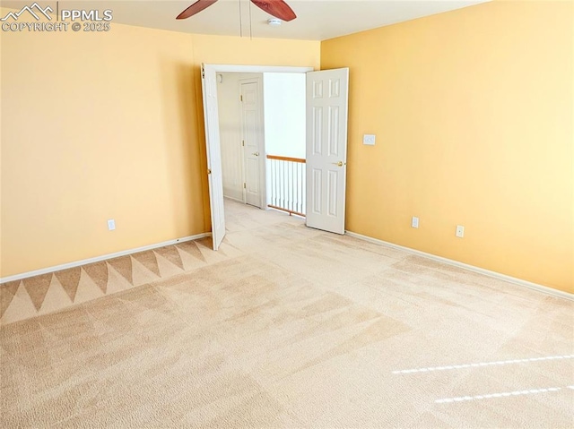 carpeted empty room featuring baseboards and ceiling fan