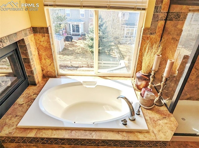 bathroom featuring a bath and a tiled fireplace