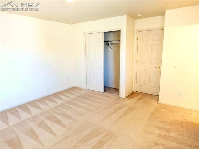 unfurnished bedroom featuring a closet and light colored carpet