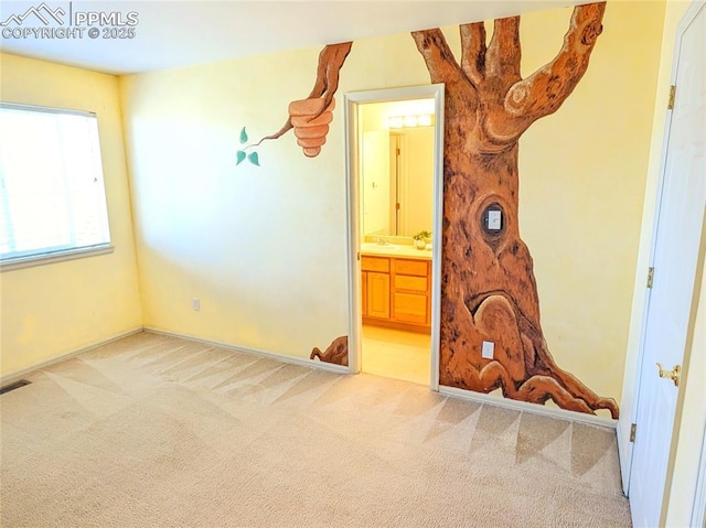 carpeted bedroom with ensuite bath, visible vents, and a sink