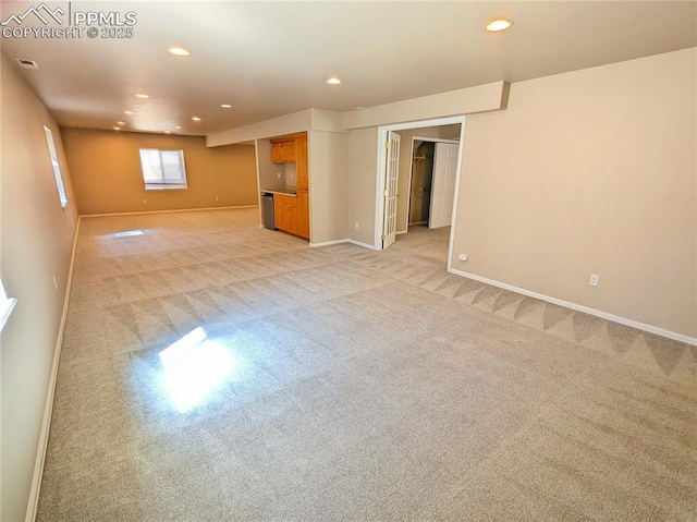 unfurnished living room with light carpet, visible vents, recessed lighting, and baseboards