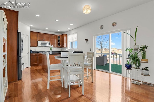 kitchen featuring dark countertops, stainless steel microwave, light wood-style flooring, and a kitchen island