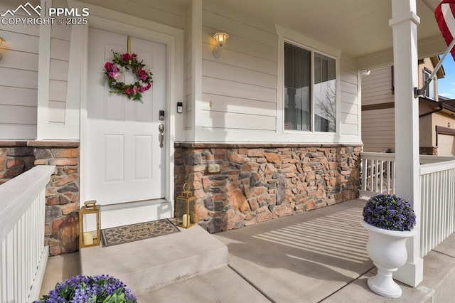 entrance to property featuring stone siding and covered porch