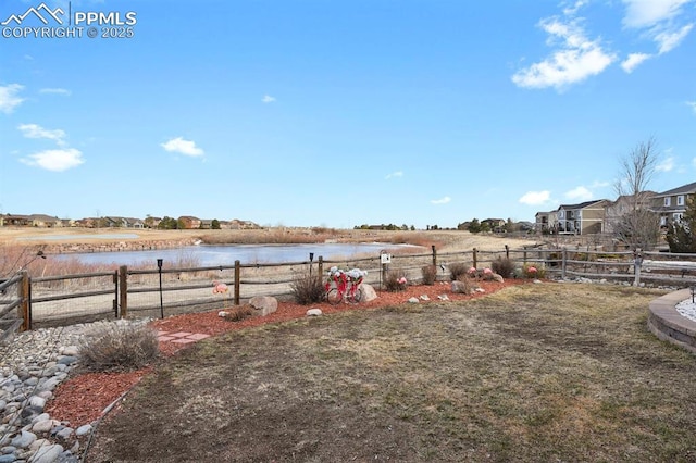 view of yard with a water view and fence