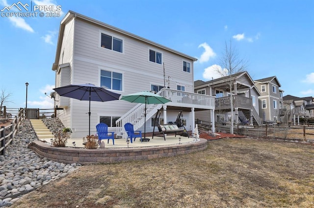 rear view of house with stairs, a deck, a patio area, and fence