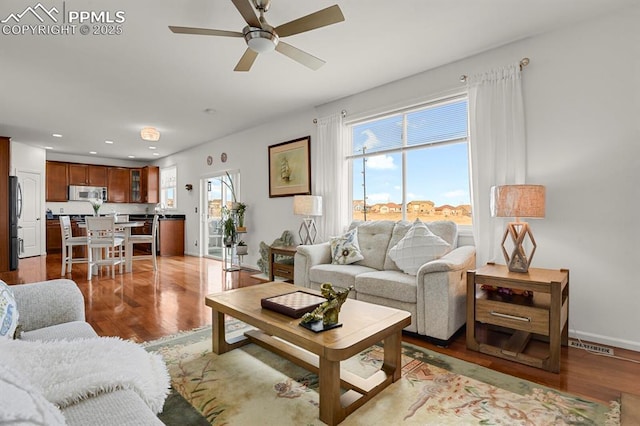 living area featuring a wealth of natural light, baseboards, wood finished floors, and recessed lighting