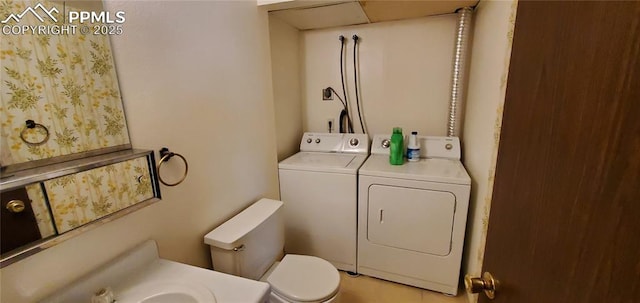 bathroom featuring washing machine and clothes dryer and toilet