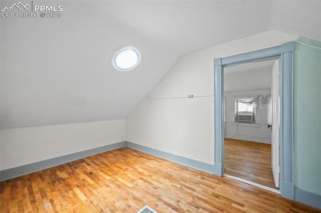 bonus room featuring lofted ceiling, baseboards, cooling unit, and wood finished floors