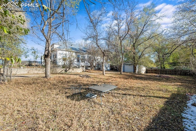 view of yard featuring an outbuilding and fence