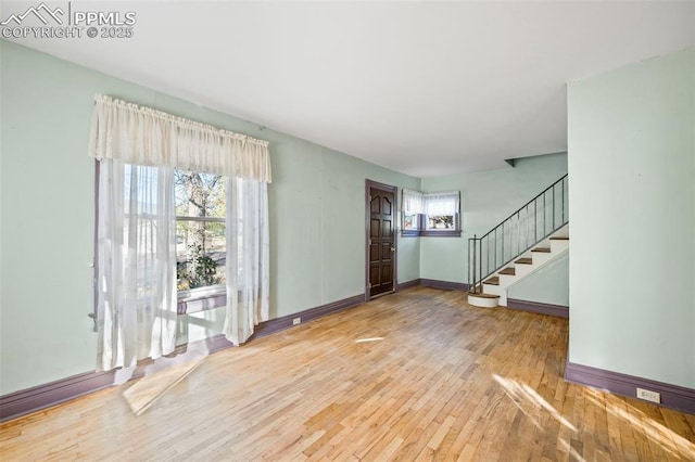 entryway featuring hardwood / wood-style flooring, stairs, and baseboards