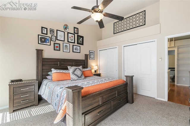 bedroom featuring a ceiling fan, light carpet, baseboards, and two closets