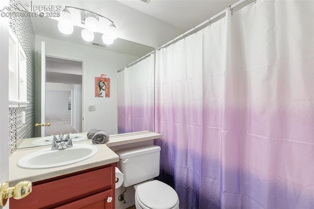 full bathroom with toilet, visible vents, and vanity