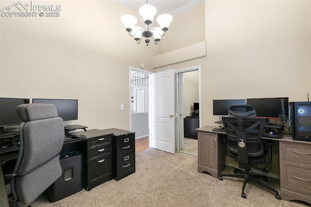 office with light carpet, a high ceiling, and a notable chandelier