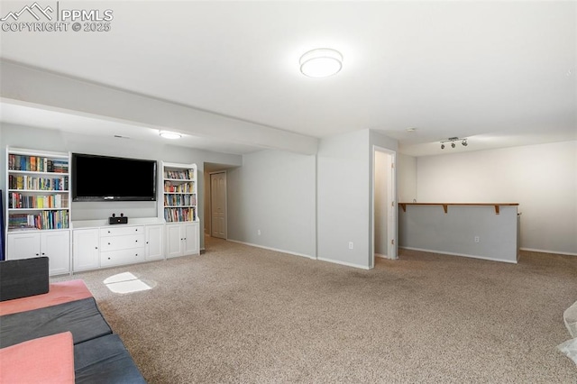 unfurnished living room featuring baseboards, carpet, and track lighting