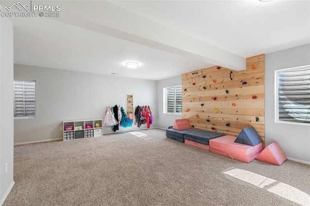 rec room featuring carpet floors, beam ceiling, and baseboards