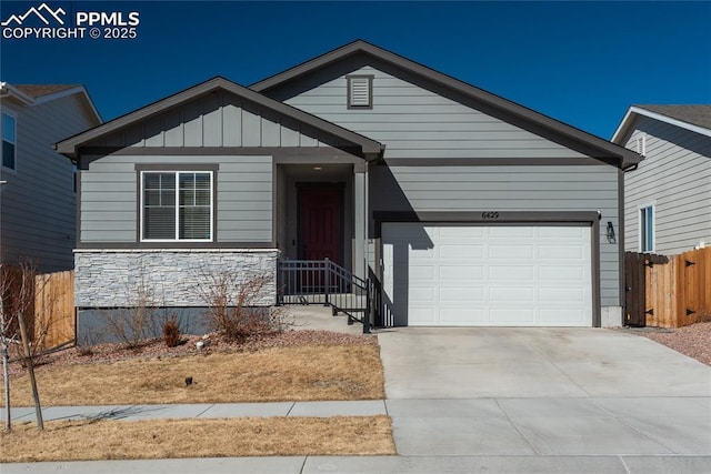 view of front of house featuring a garage, fence, concrete driveway, stone siding, and board and batten siding