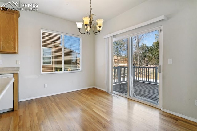 unfurnished dining area featuring light wood-style flooring, visible vents, baseboards, and a chandelier