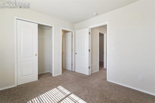 unfurnished bedroom with carpet, a closet, and baseboards