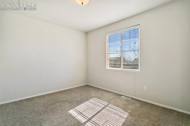 carpeted spare room featuring baseboards and visible vents