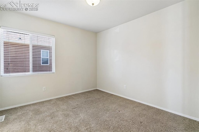 carpeted empty room featuring baseboards