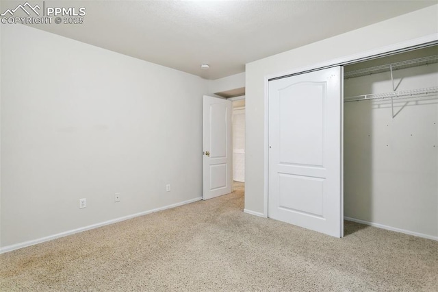 unfurnished bedroom with a closet, carpet flooring, and baseboards