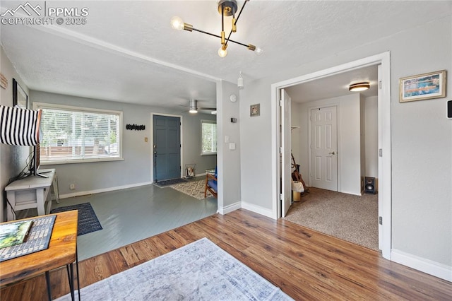 entryway with a textured ceiling, plenty of natural light, wood finished floors, and baseboards